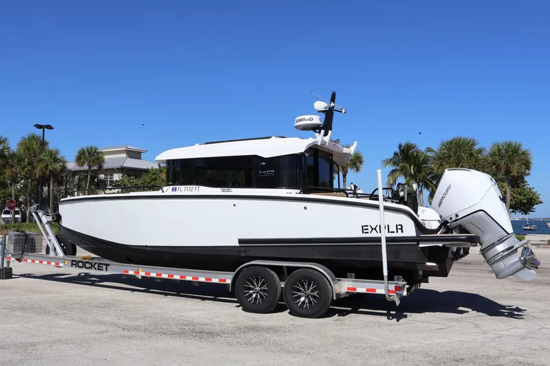  Yacht Photos Pics 2024 XO Boats EXPLR 10 S Plus on trailer, parked outdoors under clear blue sky.