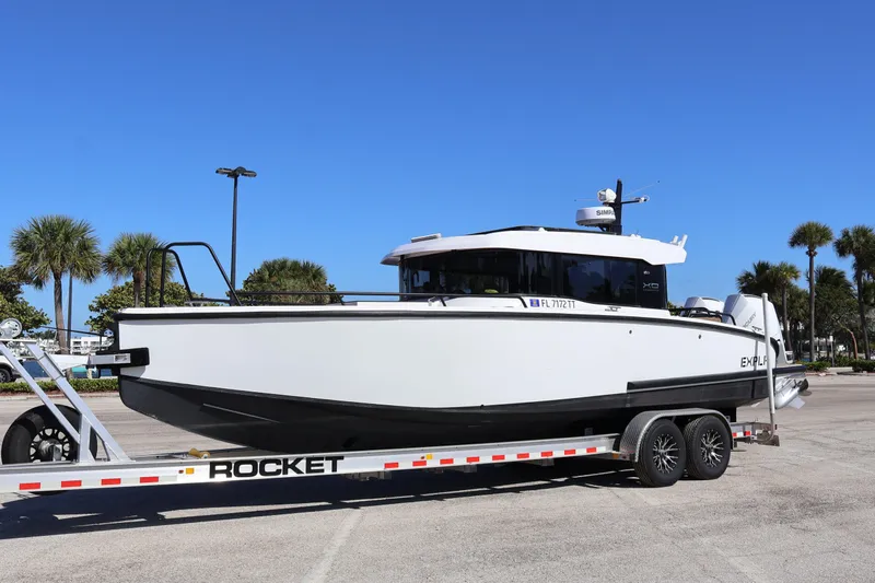  Yacht Photos Pics 2024 XO Boats EXPLR 10 S Plus on trailer, parked outdoors under clear blue sky.