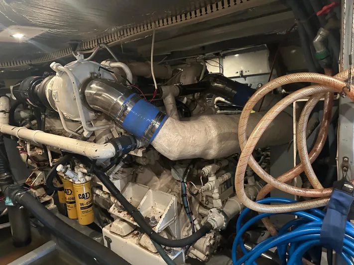  Yacht Photos Pics Engine room of a 1996 Tollycraft 57 Pilothouse Motor Yacht, showcasing complex machinery and hoses.