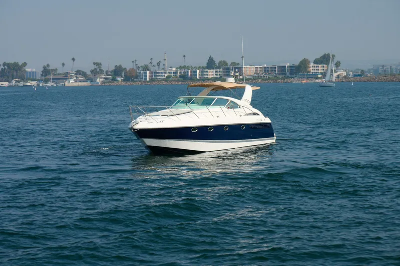 Back Up Plan Yacht Photos Pics 2001 Fairline 43 yacht cruising on calm waters near a coastal cityscape.
