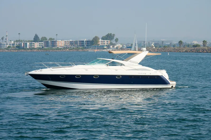 Back Up Plan Yacht Photos Pics 2001 Fairline 43 yacht cruising on calm waters near a coastal cityscape.