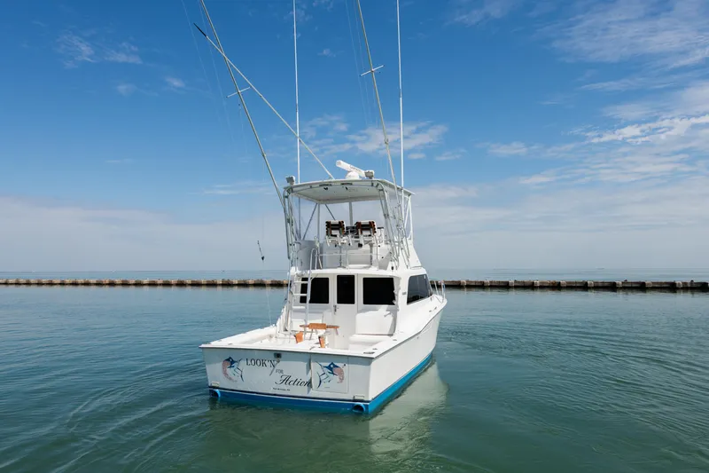  Yacht Photos Pics 2000 Cabo Convertible boat on calm water under a clear blue sky.