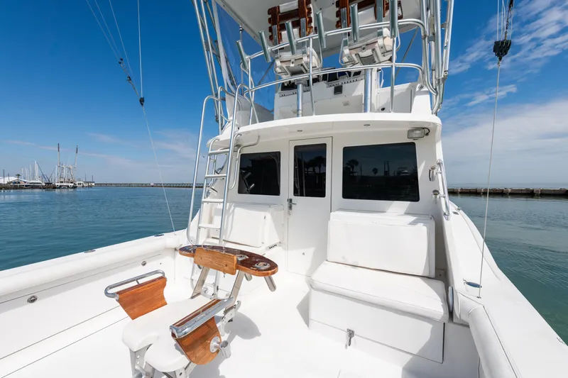  Yacht Photos Pics 2000 Cabo Convertible boat with white deck and fishing chair, docked in a marina.