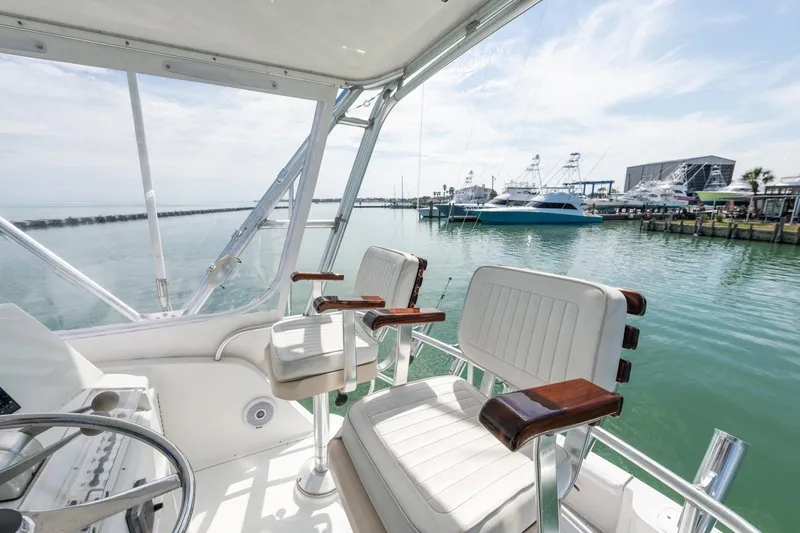  Yacht Photos Pics Cabo Convertible 2000 boat interior with marina view, featuring white seating and clear skies.