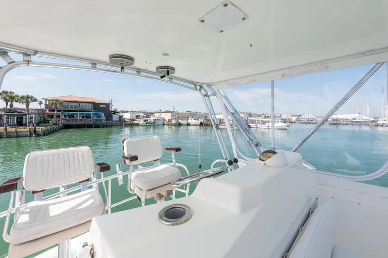 Yacht Photos Pics Cabo Convertible 2000 yacht interior with marina view, featuring white seating and clear skies.