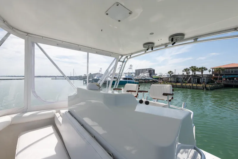  Yacht Photos Pics 2000 Cabo Convertible boat interior with marina view, featuring seating and helm station.