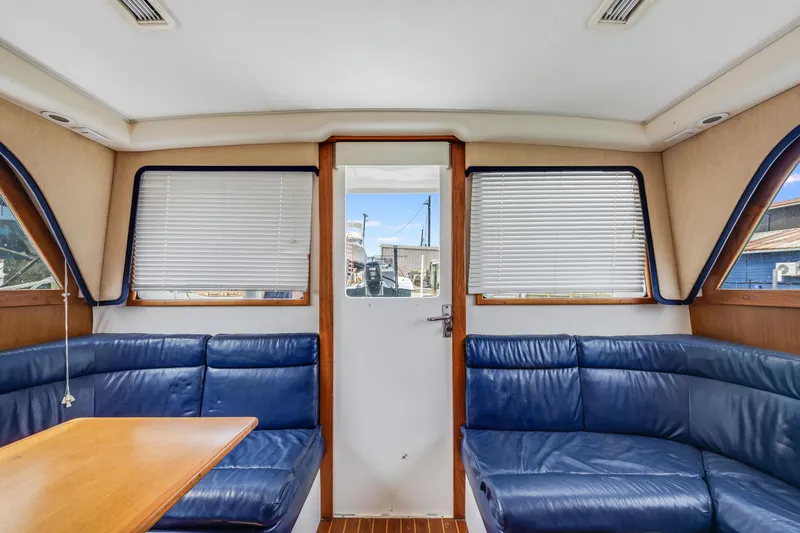  Yacht Photos Pics Interior of a 2000 Cabo Convertible boat with blue seating and wooden accents.