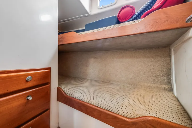  Yacht Photos Pics Interior of 2000 Cabo Convertible boat with cozy bunk bed and wooden cabinetry.