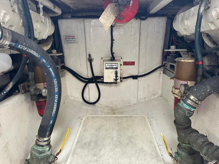  Yacht Photos Pics Engine room of a 2000 Cabo Convertible boat, featuring hoses and mechanical components.