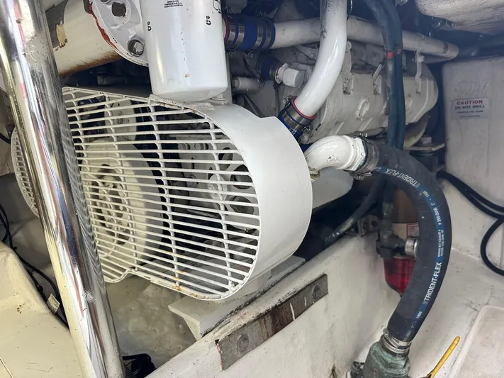  Yacht Photos Pics Engine compartment of a 2000 Cabo Convertible boat, featuring mechanical components and hoses.