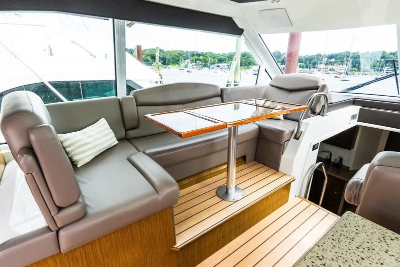  Yacht Photos Pics Luxurious interior of 2013 Cruisers Yachts 48 Cantius with plush seating and wooden table.