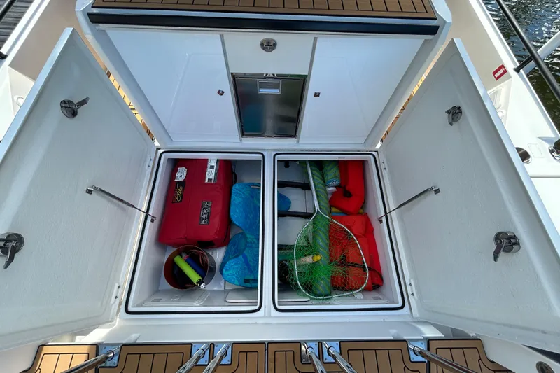 Yacht Photos Pics Storage compartments on 2018 Axopar 37 SUN TOP BRABUS, featuring fishing gear and life jackets.