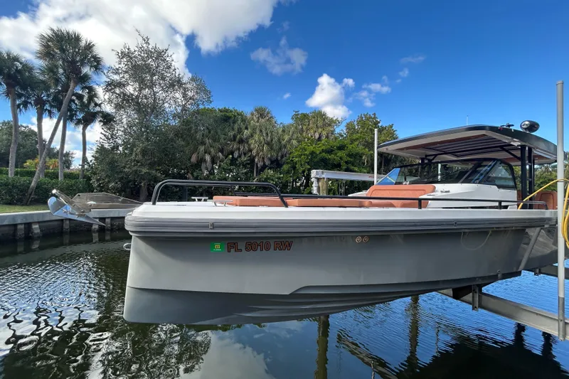  Yacht Photos Pics 2018 Axopar 37 SUN TOP BRABUS boat docked by lush greenery.