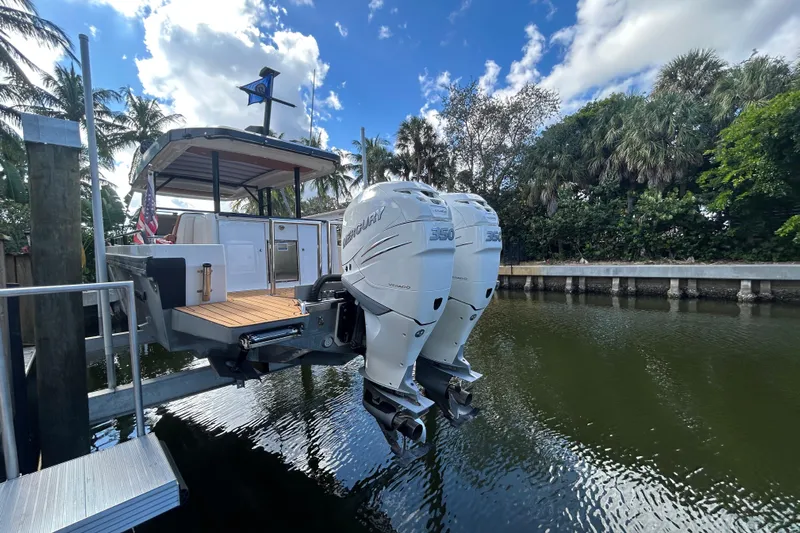  Yacht Photos Pics 2018 Axopar 37 SUN TOP BRABUS with twin Mercury 350 engines docked by lush greenery.