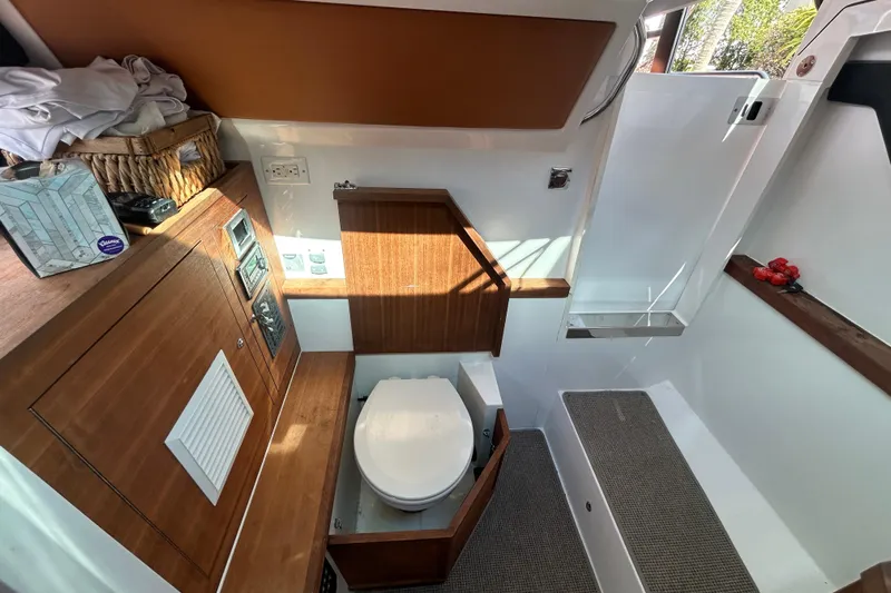  Yacht Photos Pics Interior of 2018 Axopar 37 SUN TOP BRABUS with wooden cabinetry and compact toilet.