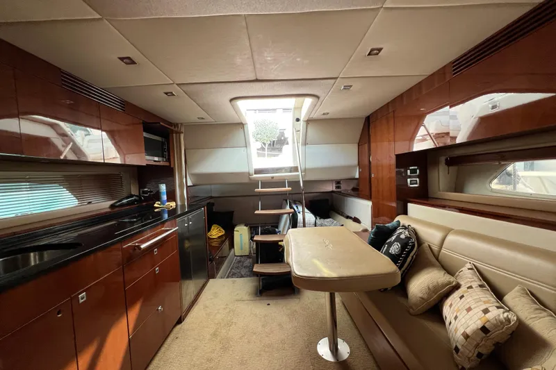  Yacht Photos Pics Luxurious interior of 2010 Sea Ray 450 Sundancer yacht with elegant wood finishes and cozy seating.