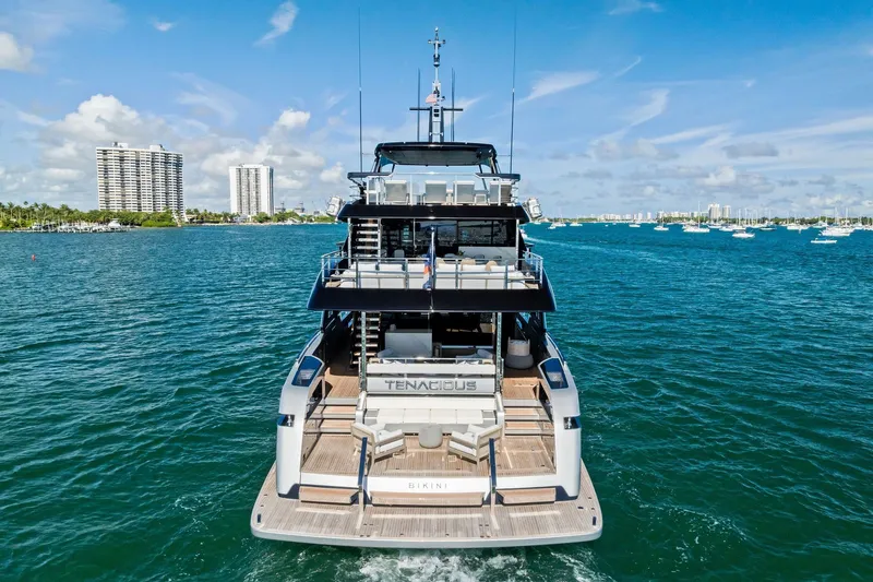 Tenacious Yacht Photos Pics Luxury yacht Riva 130' Bellissima 2025 on open water, city skyline in background.