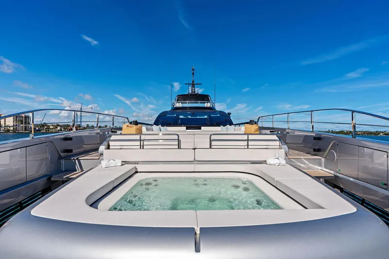 Tenacious Yacht Photos Pics Luxurious 2025 Riva 130' Bellissima yacht with jacuzzi on deck, under clear blue sky.