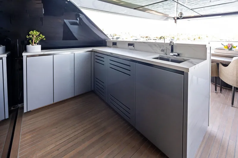 Tenacious Yacht Photos Pics Modern kitchen area on 2025 Riva 130' Bellissima yacht with sleek cabinetry and sink.
