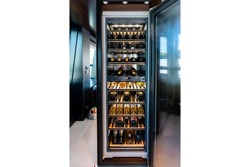 Tenacious Yacht Photos Pics Luxurious wine fridge on Riva 130' Bellissima yacht, 2025 model, showcasing premium wine collection.