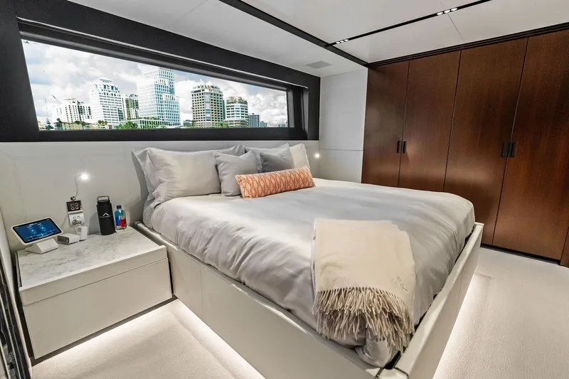 Tenacious Yacht Photos Pics Luxurious bedroom interior of 2025 Riva 130' Bellissima yacht with cityscape view.