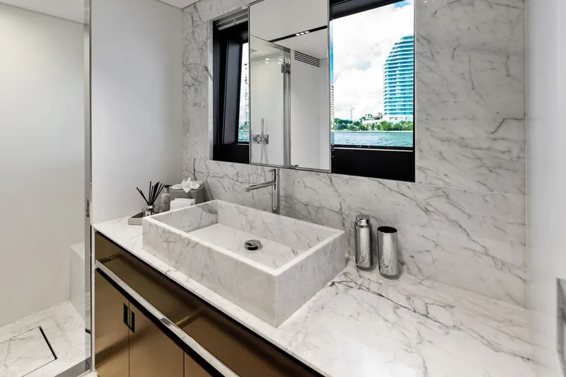 Tenacious Yacht Photos Pics Luxurious marble bathroom on 2025 Riva 130' Bellissima yacht with modern fixtures and scenic window view.