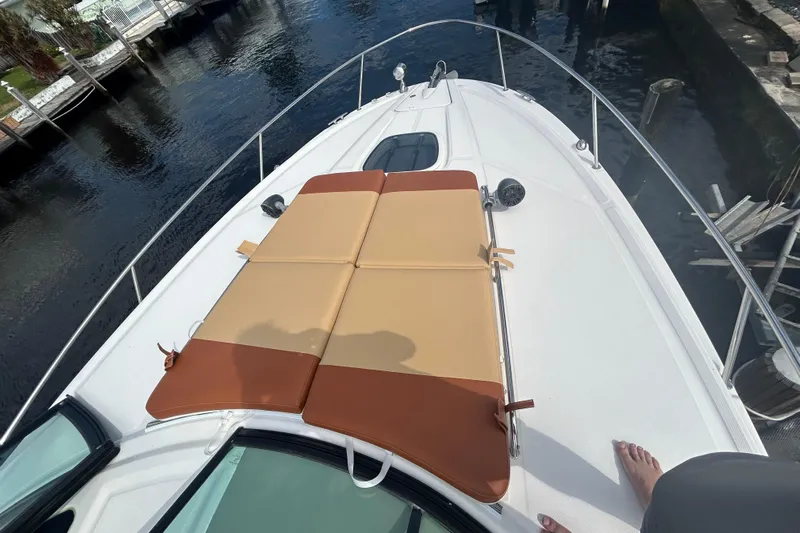 Mr Bojangles Yacht Photos Pics 2014 Sea Ray 370 Venture boat with sunpad on deck, docked by water.