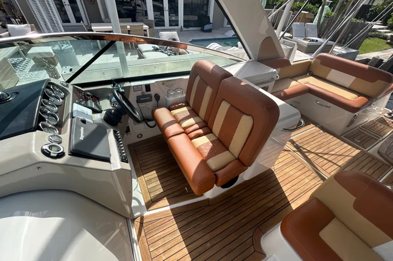 Mr Bojangles Yacht Photos Pics 2014 Sea Ray 370 Venture boat interior with tan and brown seating, wooden flooring, and control panel.