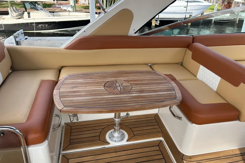 Mr Bojangles Yacht Photos Pics Luxurious seating area on a 2014 Sea Ray 370 Venture with wooden table and leather cushions.