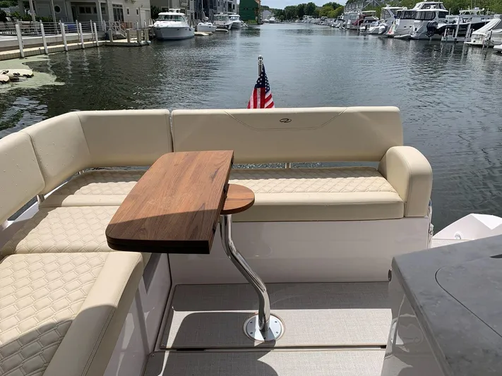  Yacht Photos Pics 2020 Regal 38 Grand Coupe yacht with elegant seating and wooden table on a serene waterway.