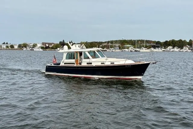  Yacht Photos Pics 2015 Sabre 42 Salon Express cruising on a calm lake with marina in background.
