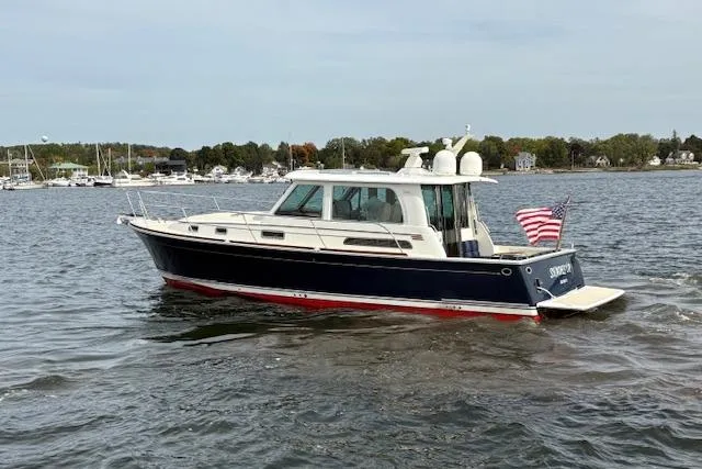  Yacht Photos Pics 2015 Sabre 42 Salon Express yacht cruising on a calm lake with American flag.