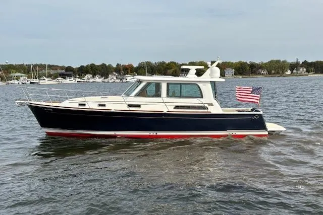  Yacht Photos Pics 2015 Sabre 42 Salon Express boat cruising on a calm lake with American flag.
