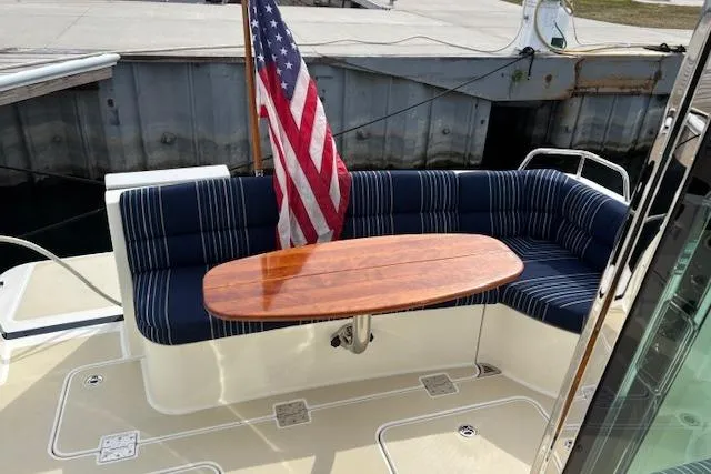  Yacht Photos Pics 2015 Sabre 42 Salon Express yacht with striped seating and wooden table on deck.