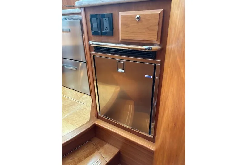  Yacht Photos Pics 2015 Sabre 42 Salon Express interior with stainless steel fridge and wooden cabinetry.