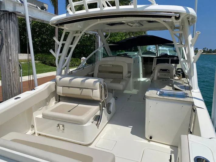 Fins Up Yacht Photos Pics 2017 Boston Whaler 320 Vantage boat interior with seating and helm, docked by the water.