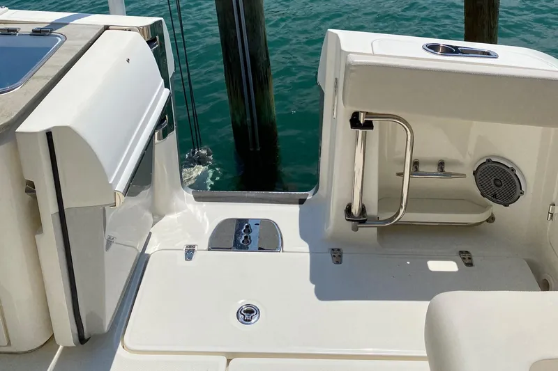 Fins Up Yacht Photos Pics 2017 Boston Whaler 320 Vantage boat deck with seating and railing, docked by water.