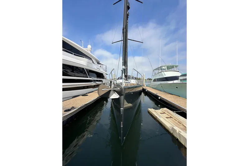 Imagine Yacht Photos Pics 2017 Jeanneau 64 yacht docked between two boats, clear sky background.