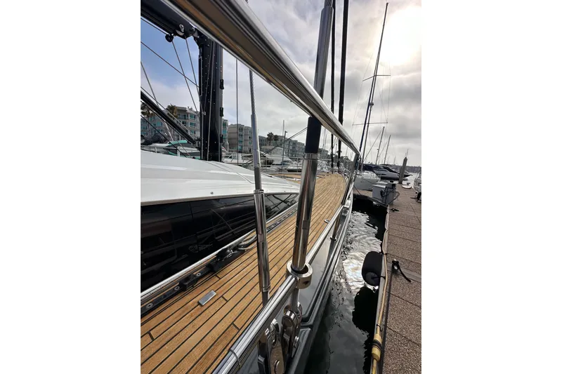 Imagine Yacht Photos Pics Jeanneau 64 yacht, 2017 model, docked with wooden deck and metal railings.