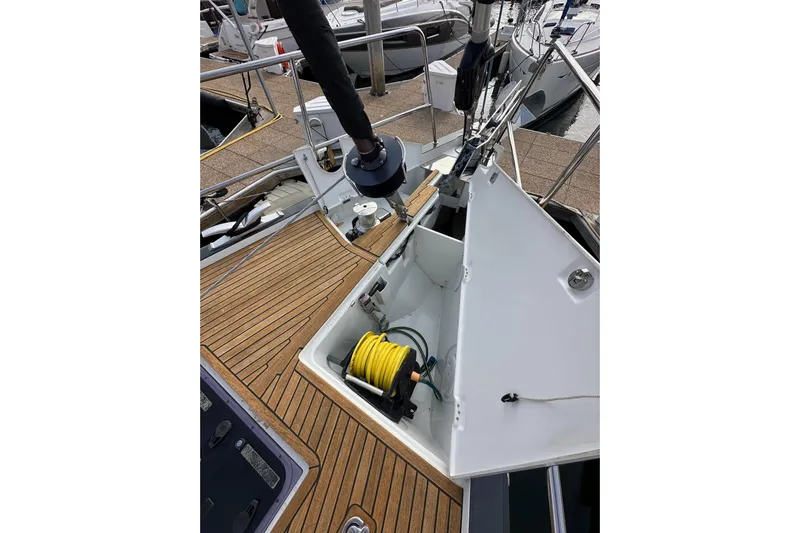 Imagine Yacht Photos Pics 2017 Jeanneau 64 sailboat deck with open storage compartment and coiled yellow hose.