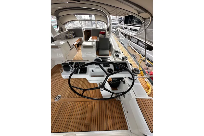 Imagine Yacht Photos Pics 2017 Jeanneau 64 yacht cockpit with steering wheel, teak flooring, and seating area.