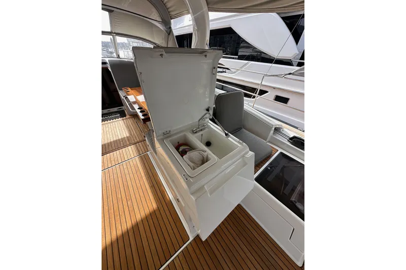 Imagine Yacht Photos Pics Open storage compartment on 2017 Jeanneau 64 yacht deck with wooden flooring.