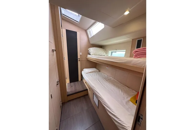 Imagine Yacht Photos Pics Cozy cabin with bunk beds in a 2017 Jeanneau 64 yacht, featuring natural light and modern design.