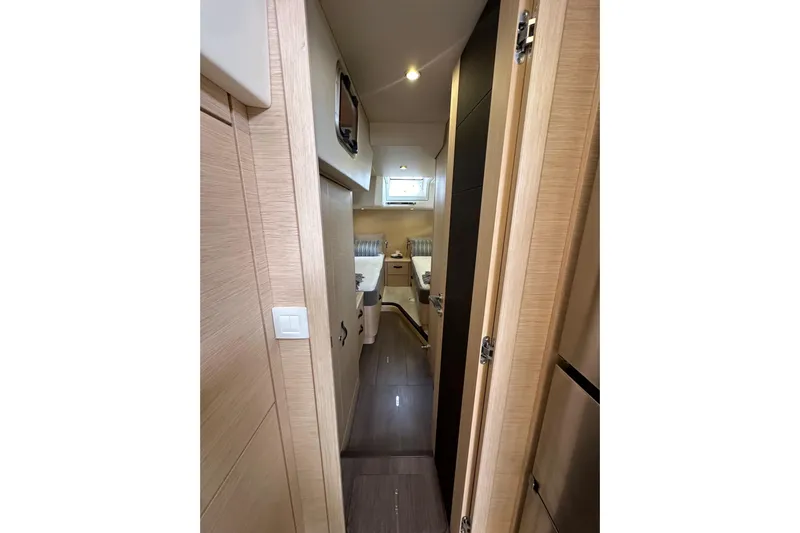 Imagine Yacht Photos Pics Interior hallway of 2017 Jeanneau 64 yacht, featuring modern wood finishes and compact design.