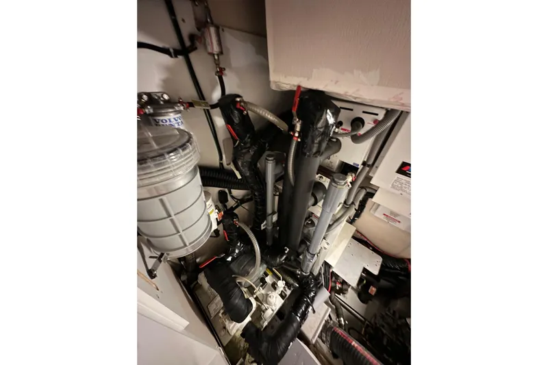 Imagine Yacht Photos Pics Engine room of a 2017 Jeanneau 64 yacht, showcasing mechanical components.