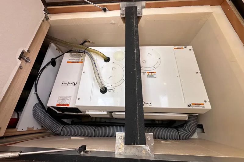 Imagine Yacht Photos Pics Engine compartment of a 2017 Jeanneau 64 yacht, showcasing mechanical components and hoses.