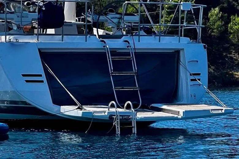 Imagine Yacht Photos Pics 2017 Jeanneau 64 yacht with open swim platform and ladder in serene waters.
