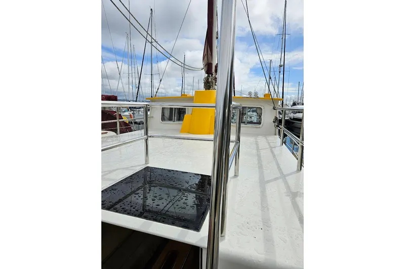 Carquinas Coot Yacht Photos Pics 2010 Seahorse COOT boat deck with yellow cabin, stainless steel railings, and marina background.