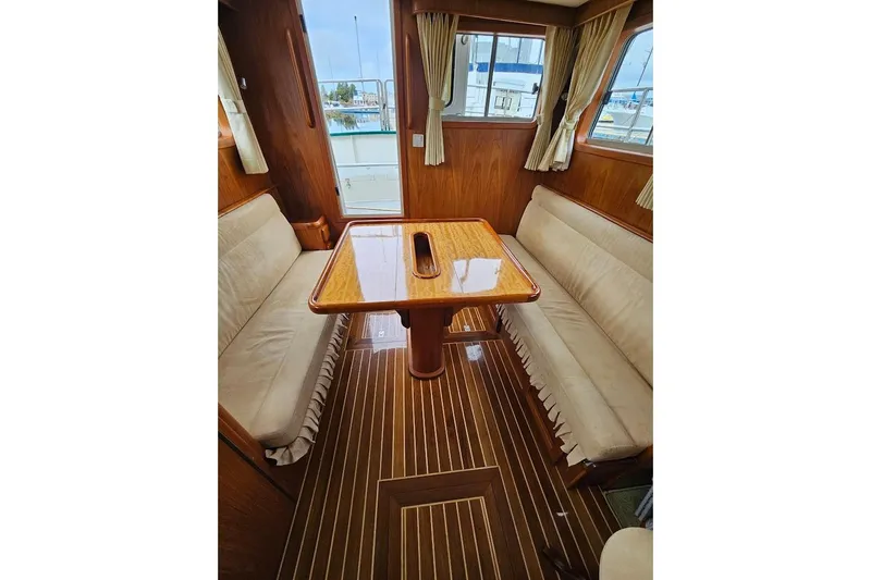 Carquinas Coot Yacht Photos Pics Interior of 2010 Seahorse COOT boat with wooden table and cushioned seating.