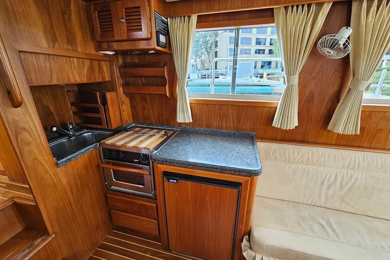 Carquinas Coot Yacht Photos Pics Cozy 2010 Seahorse COOT boat kitchen with wood finish, compact appliances, and window view.
